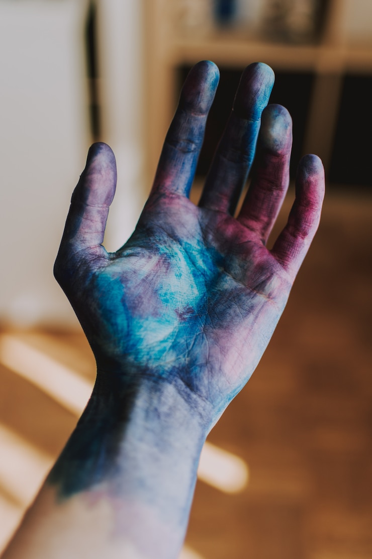 Photo gratuit gros plan sélectif tourné de la paume d'une personne en peinture bleue et rose