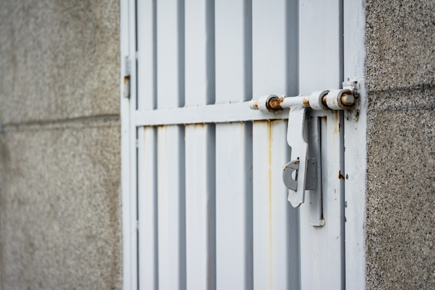 Gros plan d'une serrure rouillée sur une porte gris métal