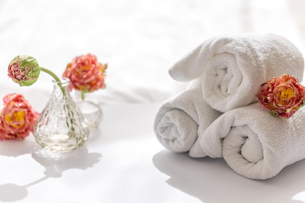 Gros plan des serviettes de bain en éponge blanche et des fleurs