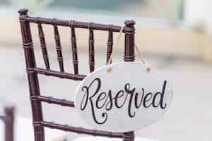 Photo gratuite gros plan d'un signe réservé accroché sur une chaise lors d'une cérémonie de mariage