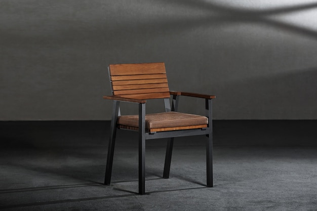 Gros plan d'une simple chaise moderne avec des pieds métalliques dans une pièce aux murs gris