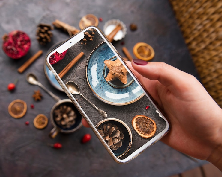Photo gratuit gros plan, de, smartphone, tenu, dessus, biscuit, à, citron séché, et, cônes pin
