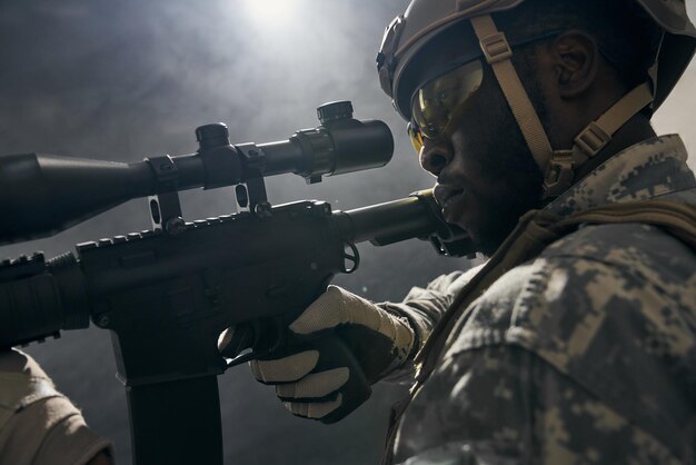 Gros plan sur un soldat américain gardant la vue sur une arme à feu moderne