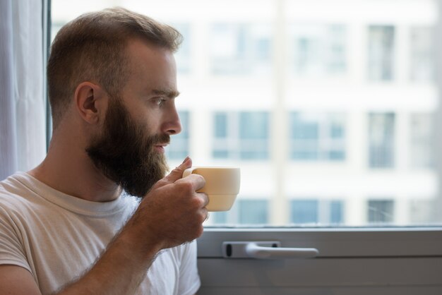 Gros plan, songeur, hipster, homme, boire, café, à, tasse