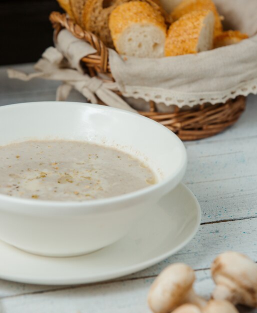 gros plan de soupe aux champignons dans un bol servi avec du pain