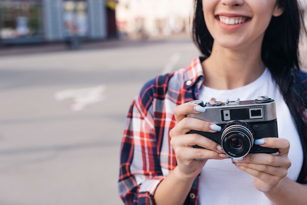 Gros plan, de, sourire, jeune femme, tenue, retro, appareil photo, dehors