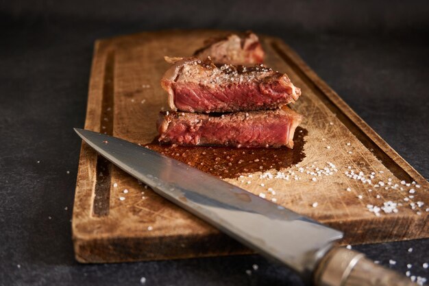 Gros plan de steak saignant sur une planche de bois