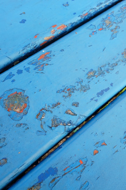 Gros plan d'une table en métal bleu avec de la peinture écaillée montrant l'ancienne couche