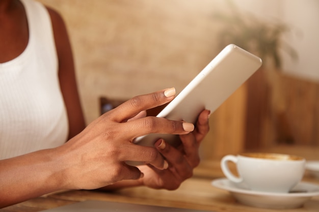 Photo gratuite gros plan de la tablette dans les mains de la femme