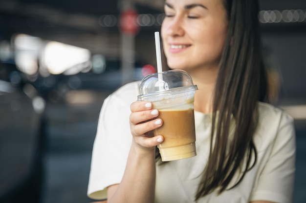 Photo gratuite gros plan sur une tasse jetable de café glacé dans des mains féminines