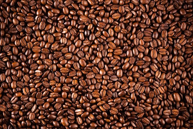 Gros plan de la texture des grains de café. Café brun, texture de fond, gros plan. Beau fond pour vos idées.