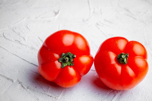 Gros plan des tomates sur fond texturé blanc. horizontal