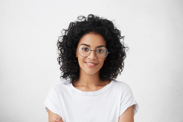 Gros plan tourné en studio de la belle jeune modèle de femme métisse aux cheveux noirs bouclés