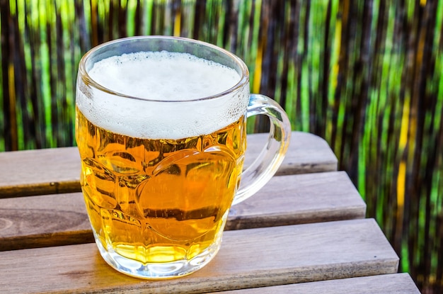 Gros plan d'un verre de bière froide sur une surface en bois