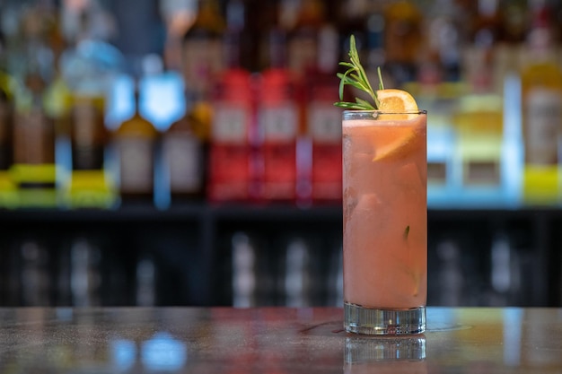 Gros plan d'un verre de cocktail glacé à l'orange sur un comptoir de bar
