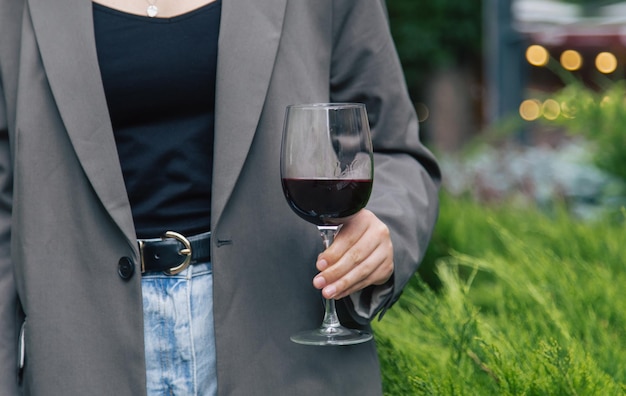 Photo gratuite gros plan un verre de vin rouge sur fond de buissons verts