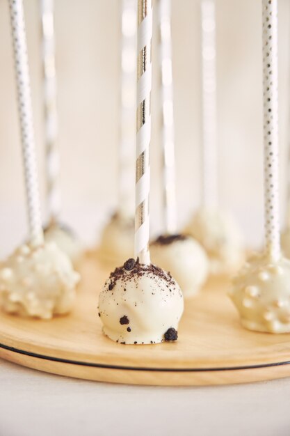 Gros plan vertical d'un délicieux gâteau blanc sur une table blanche et en bois