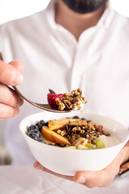 Gros plan vertical de délicieux granola avec quelques fruits et baies