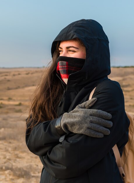 Gros plan vertical de mise au point peu profonde d'une femme s'embrassant parce que le temps froid