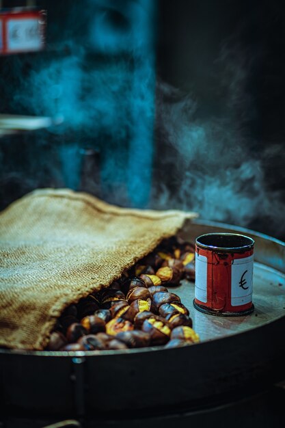 Gros plan vertical de noix grillées avec une boîte sur une casserole sous les lumières