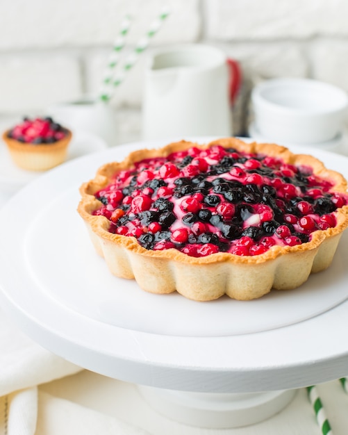 Photo gratuite gros plan vertical sélectif tourné d'une tarte aux fruits rouges et noirs