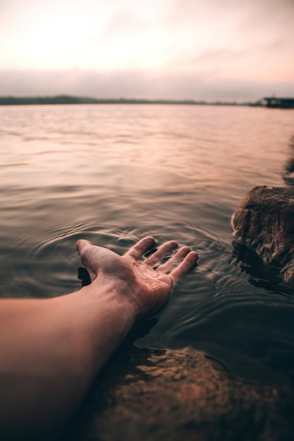 Gros Plan Vertical Tourné D'une Personne Avec Sa Main Dans L'eau