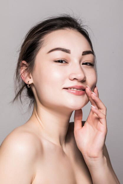 Gros plan visage de belle jeune femme isolé sur mur gris