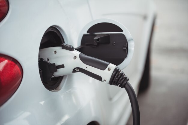 Gros plan d'une voiture en cours de chargement avec un chargeur de voiture électrique