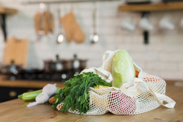 Gros sacs réutilisables avec épicerie biologique sur la table