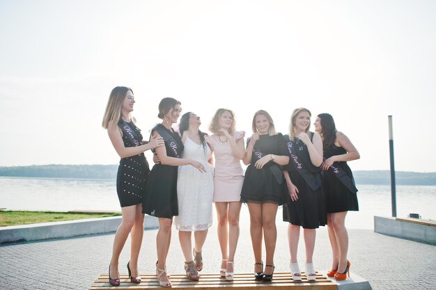 Groupe de 7 filles portant du noir et 2 mariées à la fête de poule