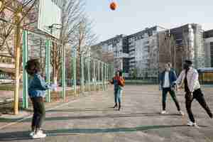 Photo gratuite groupe d'adolescents jouant au basket-ball ensemble