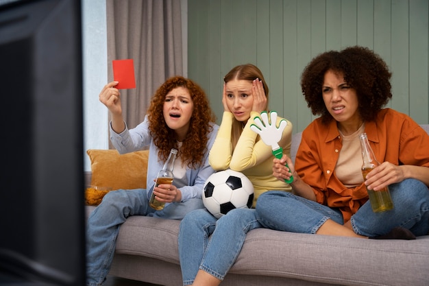 Photo gratuite groupe d'amies à la maison regardant des sports ensemble