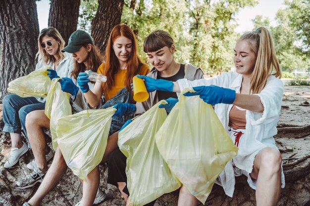 Groupe d'amis activistes ramassant des déchets plastiques dans le parc. Conservation de l'environnement.