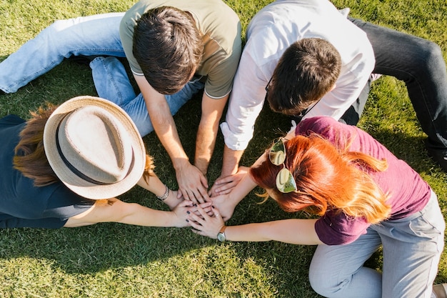 Groupe d'amis adultes rassemblant leurs mains