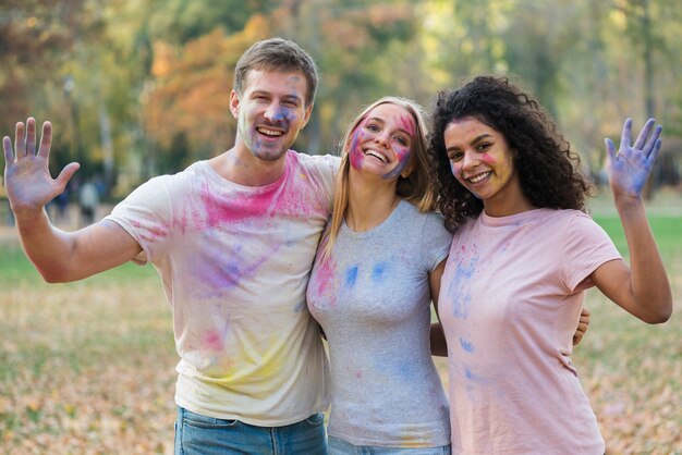 Groupe d'amis agitant leurs mains colorées