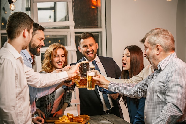 Groupe d'amis appréciant les boissons du soir avec de la bière