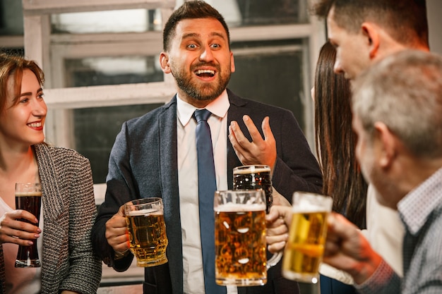 Groupe d'amis appréciant les boissons du soir avec de la bière