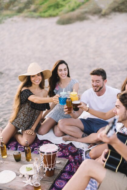 Groupe d&#39;amis assis à la plage