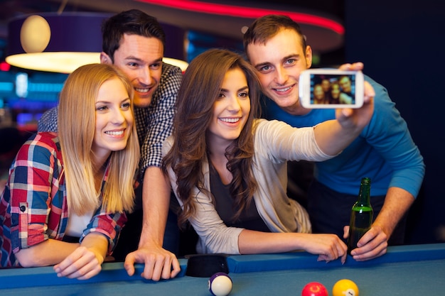 Groupe d'amis attrapant des souvenirs du club de billard