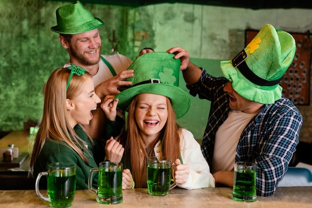 Photo gratuite groupe d'amis célébrant st. la fête de patrick avec des boissons