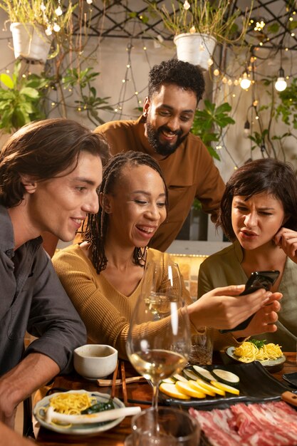 Groupe d'amis dînant au restaurant