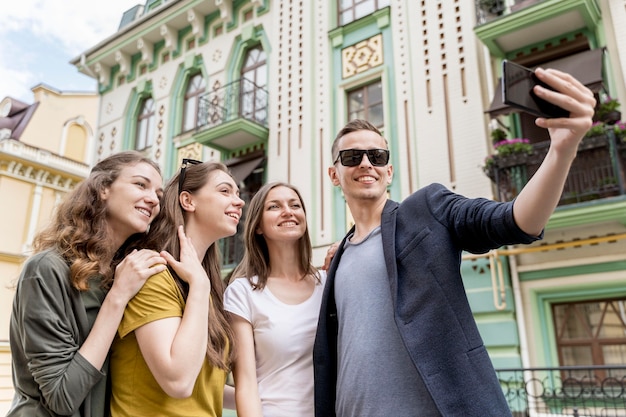 Photo gratuite groupe d'amis faible angle prenant selfie