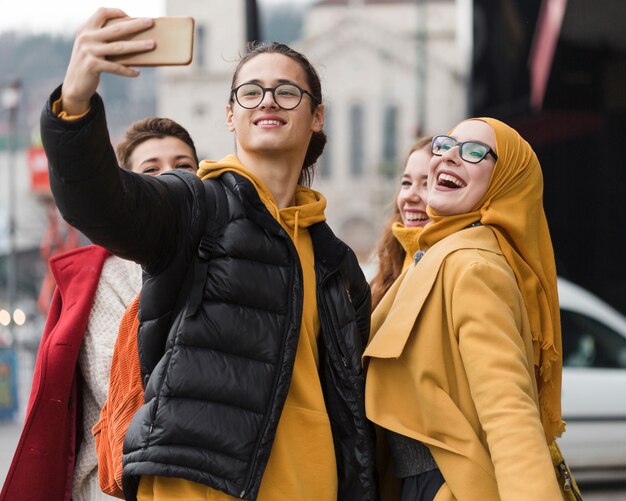 Groupe d'amis heureux prenant un selfie ensemble