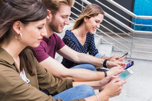 Groupe d&#39;amis heureux en regardant l&#39;écran du téléphone portable