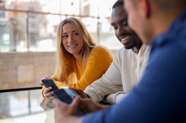 Groupe d'amis lisant des messages de téléphone portable