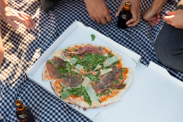 Groupe d'amis, manger des pizzas à l'extérieur