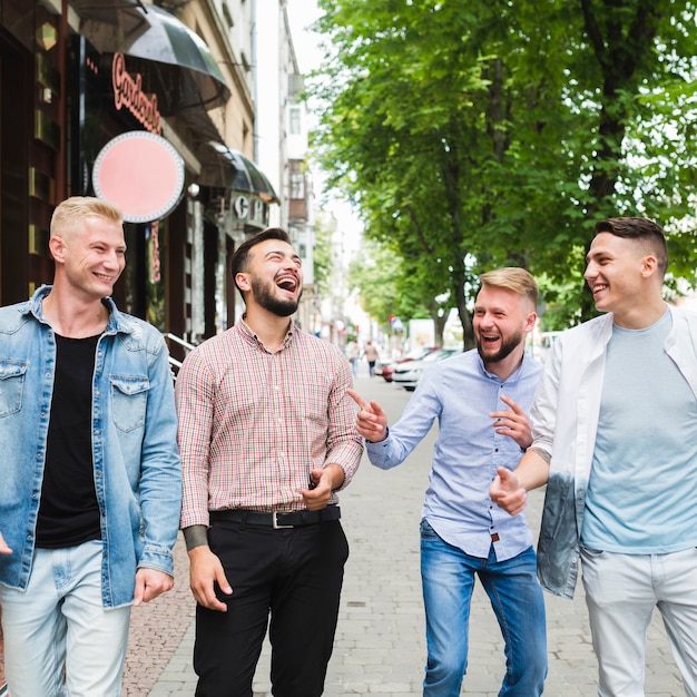 Photo gratuite groupe d'amis marchant dans la rue en se moquant