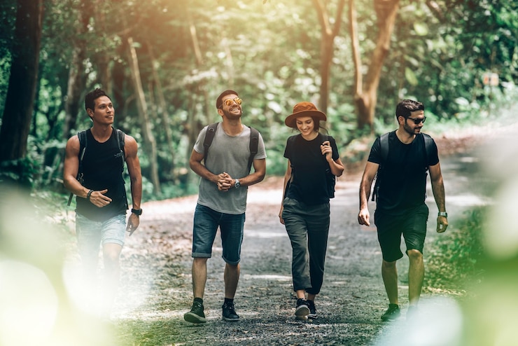 Photo gratuit groupe d'amis marchant ensemble dans la forêt pour l'aventure et l'exploration de voyages dans le concept de vacances d'été