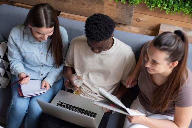 Photo gratuite groupe d'amis planifiant un voyage dans un café