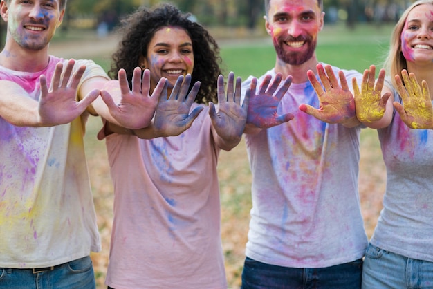 Photo gratuite groupe d'amis posant avec des mains colorées à holi